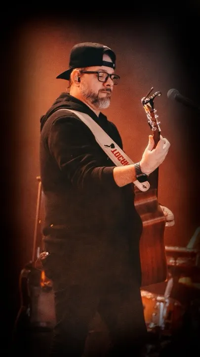 Juninho Coelho tocando violão no palco
